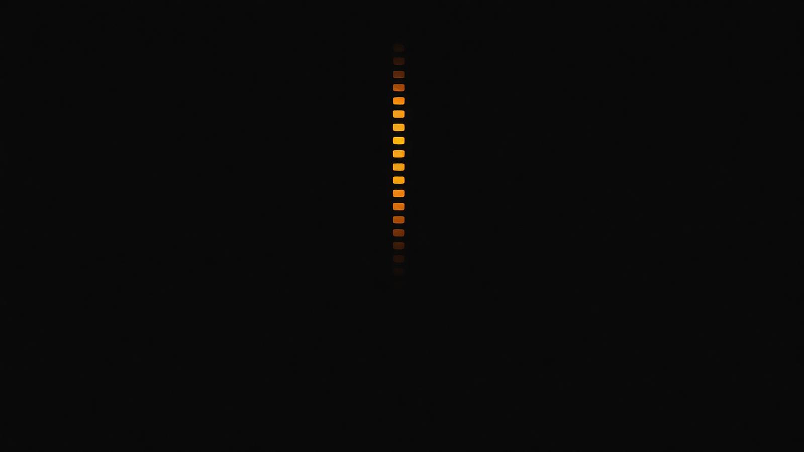 Rows of light rising into the dark, one row glowing